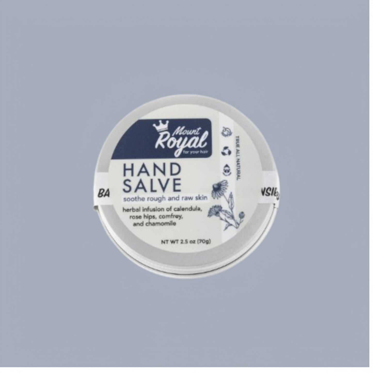 A tin of Mount Royal Hand Salve with natural ingredients like shea butter, beeswax, and dried botanicals, highlighting its herbal, nourishing formula.