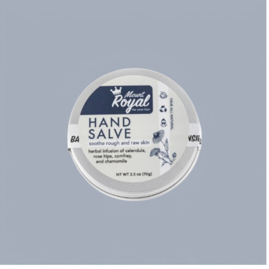 A tin of Mount Royal Hand Salve with natural ingredients like shea butter, beeswax, and dried botanicals, highlighting its herbal, nourishing formula.